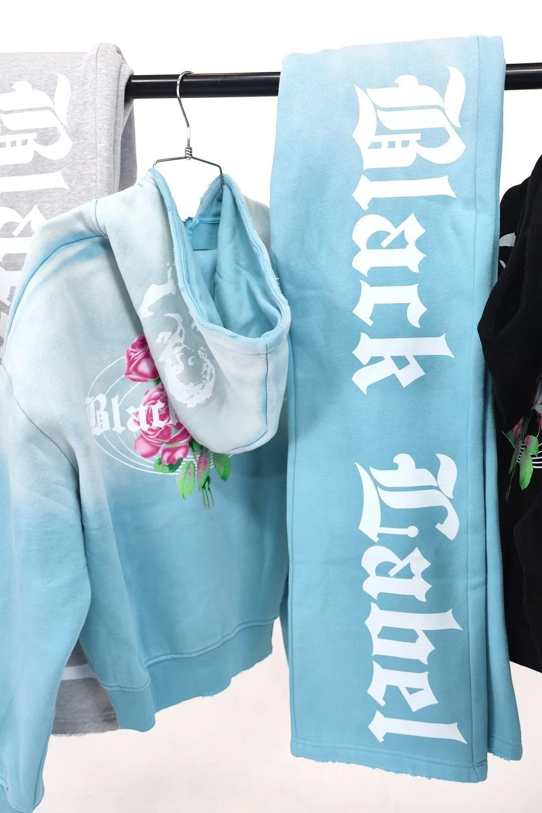 Black Label Clothing Brand blue tie-dye hoodie with pink roses graphic and raw hem. Matching sweatpants with white logo.